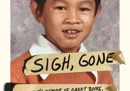 A young boy with a book on his face.